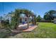 Backyard with a deck and pergola covered with vines, providing shade and a beautiful view at 1896 Mova St, Sarasota, FL 34231