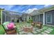 Inviting backyard featuring a stone fire pit, comfortable seating, lush landscaping, and screened-in pool area in the background at 1910 Datura St, Sarasota, FL 34239