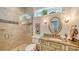 Elegant bathroom with glass shower, stone countertops, and decorative mirror at 1910 Datura St, Sarasota, FL 34239