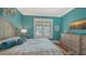 Bright bedroom with shutters and teal walls showcases a dresser and patterned bedspread at 1910 Datura St, Sarasota, FL 34239