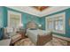 Cozy bedroom features bright blue walls, plantation shutters, and soft rug under a wood bed at 1910 Datura St, Sarasota, FL 34239