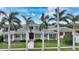 Inviting home with lush landscaping, palm trees, and charming front porch, creating a welcoming curb appeal at 1910 Datura St, Sarasota, FL 34239