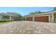 Elegant home featuring a large three-car garage and sprawling brick driveway, adding to the property's allure at 1910 Datura St, Sarasota, FL 34239