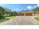 Spacious three-car garage with decorative wood doors and a paved driveway enhancing the property's exterior at 1910 Datura St, Sarasota, FL 34239