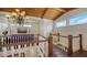 Spacious hallway with hardwood floors, wood railings, an ornate chandelier and natural lighting at 1910 Datura St, Sarasota, FL 34239