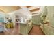 Spacious kitchen with light green cabinetry, island with seating, and hardwood floors, ideal for entertaining at 1910 Datura St, Sarasota, FL 34239