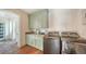 Well-equipped laundry room featuring a modern washer and dryer, complemented by stylish green cabinetry and granite countertops at 1910 Datura St, Sarasota, FL 34239