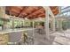 Outdoor kitchen with bar seating, stone accents, stainless steel appliances, and covered dining area at 1910 Datura St, Sarasota, FL 34239