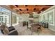 Inviting outdoor kitchen and dining area with a wooden ceiling, built-in grill, and lush landscaping at 1910 Datura St, Sarasota, FL 34239