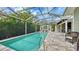 Screened-in pool area surrounded by lush landscaping with outdoor dining and lounging areas at 1910 Datura St, Sarasota, FL 34239