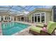 Inviting screened-in pool area with in-water lounging and covered patio, ideal for relaxing and entertaining at 1910 Datura St, Sarasota, FL 34239
