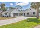 Charming curb appeal featuring a gray garage door, white accents, and lush landscaping at 2049 E Leewynn Dr, Sarasota, FL 34240
