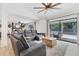 Bright living room featuring a large sectional couch, light wood floors, and access to the outdoor patio at 2049 E Leewynn Dr, Sarasota, FL 34240