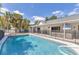 Sparkling pool with lush landscaping, a safety fence, and an inviting lounge area at 2049 E Leewynn Dr, Sarasota, FL 34240