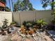 Private backyard oasis featuring a garden with colorful plants and a well-maintained fence at 2058 Sunset Point Rd # 11, Clearwater, FL 33765