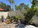 Backyard features privacy fence, rock garden with bromeliads and potted plants, and shaded patio at 2058 Sunset Point Rd # 11, Clearwater, FL 33765