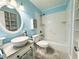 Well-lit bathroom with decorative blue walls, a modern vessel sink, and a shower over tub at 2058 Sunset Point Rd # 11, Clearwater, FL 33765
