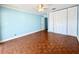 Spacious bedroom features parquet floors, large closet, ceiling fan, and natural light at 2058 Sunset Point Rd # 11, Clearwater, FL 33765