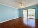 Bright bedroom with large sliding glass door to the patio and hardwood floors at 2058 Sunset Point Rd # 11, Clearwater, FL 33765