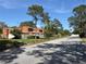 Neighborhood street view with single-Gathering homes surrounded by mature trees at 2058 Sunset Point Rd # 11, Clearwater, FL 33765