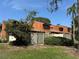 Two-story townhouse featuring wood siding, fenced yard, and colorful landscaping at 2058 Sunset Point Rd # 11, Clearwater, FL 33765
