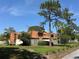 A townhouse complex featuring wood siding, fenced yards, and mature landscaping at 2058 Sunset Point Rd # 11, Clearwater, FL 33765