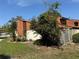 Two-story townhouse featuring wood siding, fenced yard, and mature landscaping at 2058 Sunset Point Rd # 11, Clearwater, FL 33765