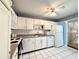 Functional kitchen with white appliances, light cabinetry and contrasting countertops at 2058 Sunset Point Rd # 11, Clearwater, FL 33765