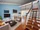 Bright, open living room with fireplace and hardwood floors, flowing to the second-floor balcony and entrance at 2058 Sunset Point Rd # 11, Clearwater, FL 33765