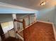 A view from the top of the wood staircase with parquet flooring to the living room below at 2058 Sunset Point Rd # 11, Clearwater, FL 33765