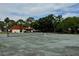 Community tennis courts with green surface and net, surrounded by trees and buildings at 2058 Sunset Point Rd # 11, Clearwater, FL 33765