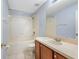 Bathroom features tiled flooring, a white tub and shower, and a wood vanity at 220 Coquina Bay Dr, St Petersburg, FL 33705