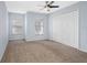 Bedroom features two windows, tan carpeting, and a ceiling fan at 220 Coquina Bay Dr, St Petersburg, FL 33705