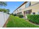 Exterior view of the home with a private screened patio, lush lawn, and a privacy fence at 220 Coquina Bay Dr, St Petersburg, FL 33705