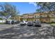 Exterior view of a multi-unit condo building with assigned parking and well-maintained landscaping at 220 Coquina Bay Dr, St Petersburg, FL 33705