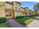 Charming townhome with well-maintained landscaping, a brick walkway, and a colorful, inviting exterior at 220 Coquina Bay Dr, St Petersburg, FL 33705
