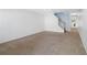 Spacious living room with neutral carpet, white walls, and a staircase leading to the upper level at 220 Coquina Bay Dr, St Petersburg, FL 33705