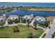 Beautiful aerial view of waterfront houses with well-maintained lawns and landscaping near a scenic lake and ocean at 230 Sapphire Lake Dr # 201, Bradenton, FL 34209