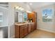Bathroom featuring double sinks with granite countertops and wooden cabinets at 230 Sapphire Lake Dr # 201, Bradenton, FL 34209