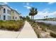 Picturesque walking path along a waterfront community, showcasing lush landscaping and blue skies at 230 Sapphire Lake Dr # 201, Bradenton, FL 34209