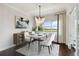 Sunlit dining room features a stylish chandelier, modern table, and scenic water views at 230 Sapphire Lake Dr # 201, Bradenton, FL 34209