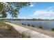 Scenic pond view with lush greenery and walking path, offering a serene outdoor experience at 230 Sapphire Lake Dr # 201, Bradenton, FL 34209