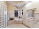 Bright bathroom featuring a soaking tub, glass block shower, and dual vanity at 2301 Little Country Rd, Parrish, FL 34219