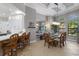 Bright dining area featuring a modern chandelier, barstool seating, and views of the lush backyard at 2301 Little Country Rd, Parrish, FL 34219