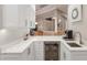 Bright kitchenette with white cabinetry, marble countertops, and a stainless steel beverage fridge at 2301 Little Country Rd, Parrish, FL 34219