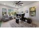 Bright office with multiple windows, a ceiling fan, and views of the backyard from the workspace at 2301 Little Country Rd, Parrish, FL 34219