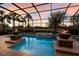 Sparkling pool and spa with fire bowls, surrounded by lush landscaping in a screened enclosure at 2301 Little Country Rd, Parrish, FL 34219