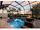 Screened pool and spa area with fire bowls, lush landscaping, and golf course views at 2301 Little Country Rd, Parrish, FL 34219