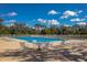Community pool with lounge chairs, tables and umbrellas, and beautiful blue sky at 2301 Little Country Rd, Parrish, FL 34219