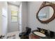 Stylish powder room featuring a black toilet, dark wood vanity, and a round mirror, ideal for guests at 2301 Little Country Rd, Parrish, FL 34219
